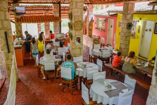 a group of people sitting at tables in a restaurant at Pousada das Arvores in Lençóis