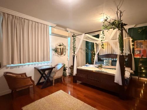 a bedroom with a bed with a window and a table at The Oasis on 8 Cozy Homestay & Café in Bangkok