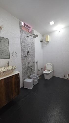 a bathroom with two toilets and a shower and a sink at Lucky garden inn in Chennai