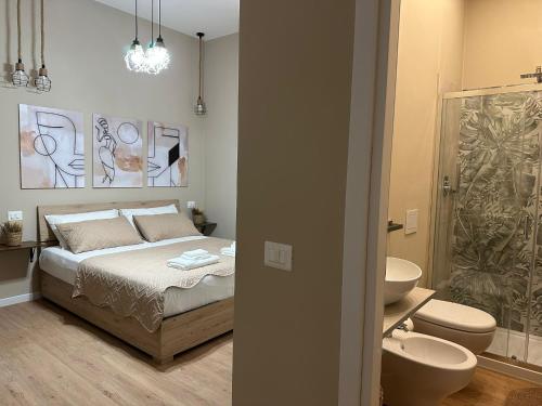 a bedroom with a bed and a bathroom with a sink at Affittacamere Yara 5 Terre in La Spezia