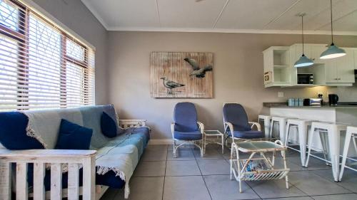 a living room with a blue couch and a kitchen at Sue Casa 3 in Margate