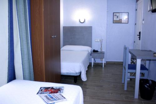 a hospital room with two beds and a desk at Hotel Universal Murcia in Murcia