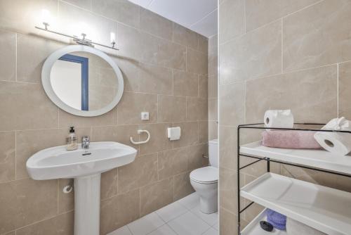 a bathroom with a sink and a toilet and a mirror at Resguardo en la playa in Calafell