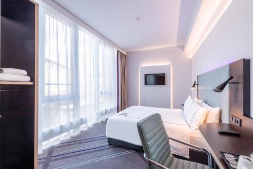 a hotel room with a bed and a desk at Premier Inn München Messe in Haar