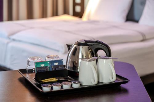 a tray with a tea kettle and cupcakes on a table at Premier Inn Stuttgart City Centre in Stuttgart