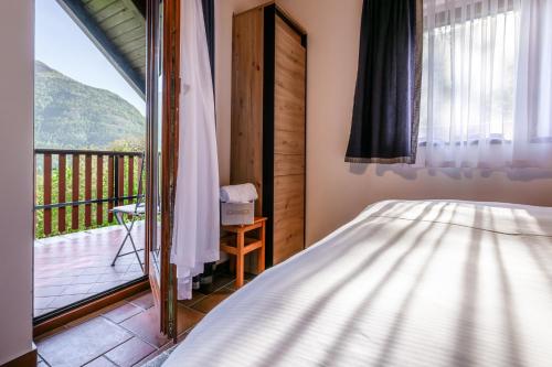 a bedroom with a bed and a balcony at Albatros in Bovec