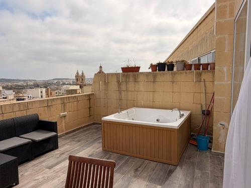 a bath tub sitting on top of a building at De Rock Penthouse in Sannat