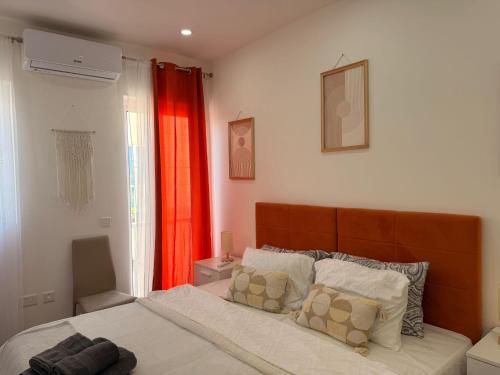 a bedroom with a bed and a red curtain at De Rock Penthouse in Sannat