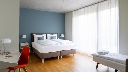 a bedroom with a bed and a desk and a chair at Gästehaus Hunziker in Zurich