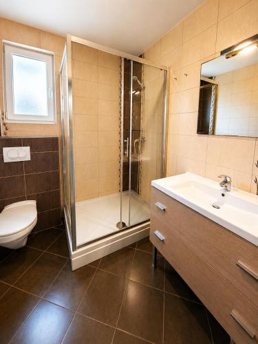 a bathroom with a shower and a toilet and a sink at Apartments Mia in Baška