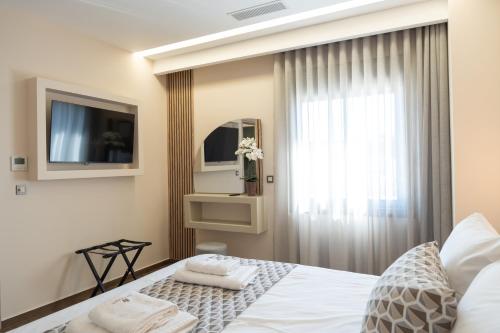 a bedroom with a bed and a tv and a window at Antaia 1 in Nafplio
