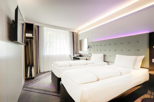 a hotel room with two beds and a television at Premier Inn Berlin City Centre in Berlin
