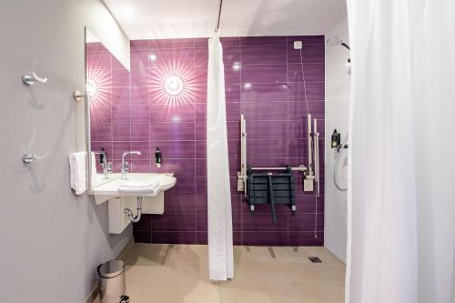 a purple bathroom with a sink and a shower at Premier Inn München Airport Ost in Oberding
