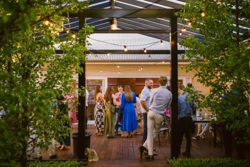a group of people standing around in a patio at The Historic Railway Barracks in Goulburn