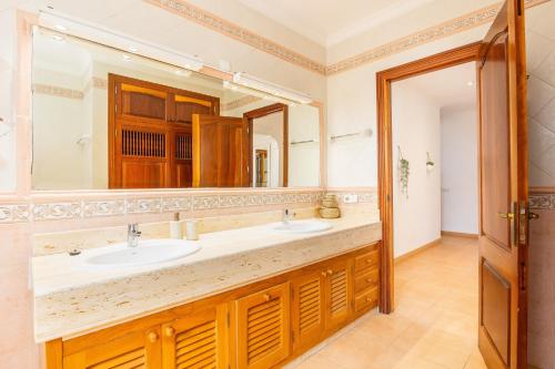 a bathroom with a sink and a large mirror at Villa Cal Peso in Port de Pollensa