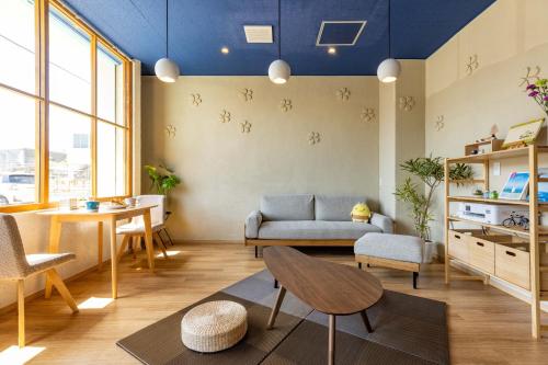a living room with a couch and a table at Guest House BLUE DOOR in Imabari Railway Station