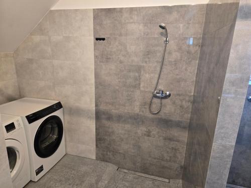 a shower with a washing machine in a bathroom at KWT Hostel Nowogard - Self Check-In - Wejscie na KOD in Nowogard
