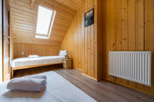 a room with two beds in a wooden cabin at Widokowa osada drewnianych domków, tuż przy szlakach turystycznych in Brenna