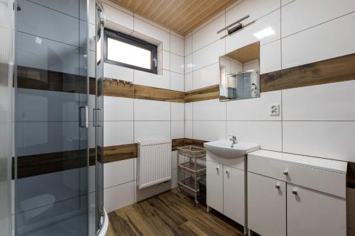 a bathroom with a sink and a shower at Widokowa osada drewnianych domków, tuż przy szlakach turystycznych in Brenna