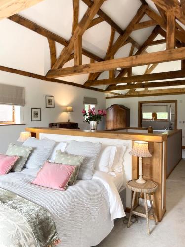 a bedroom with a bed and a table with a lamp at The Silver Suite at Manor Farm in Edenbridge