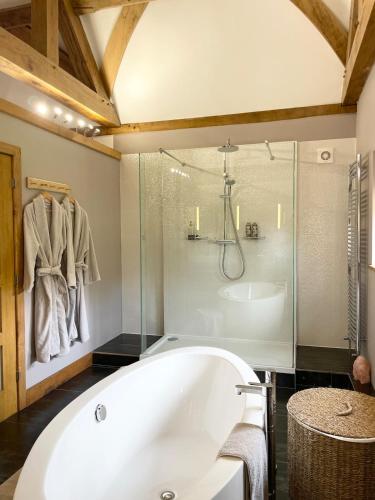 a bathroom with a tub and a glass shower at The Silver Suite at Manor Farm in Edenbridge