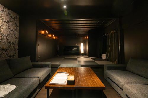 a living room with couches and a table in a room at Hakuba Hatago Maruhachi in Hakuba