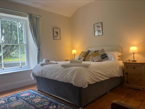 a bedroom with a large bed and a window at Castle Lodge Haughton Castle in Hexham