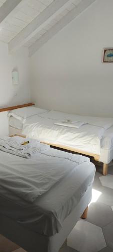 two beds in a room with white walls at CASA LUIGIA ROOMS MTB in FINALBORGO Bike room in Finale Ligure
