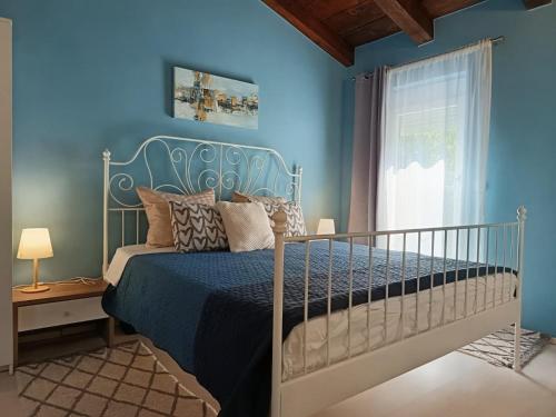 a blue bedroom with a bed and a window at Haus Stepcich in Plomin