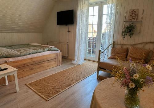 ein Wohnzimmer mit einem Bett und einer Couch in der Unterkunft SleepOrup in Faxe