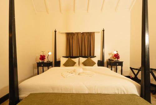 a bedroom with a bed with a large white bedspread at Fort Tiracol Goa in Arambol