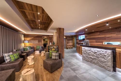 a lobby of a hotel with couches and a bar at Ravelli Sporting in Mezzana