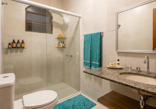 a bathroom with a shower and a toilet and a sink at Casa Aconchegante para até 6 Pessoas a 100m do Mar in São Sebastião