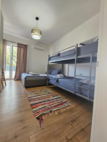 a bedroom with two bunk beds and a rug at Baza Hostel - Swimming Pool in Berat