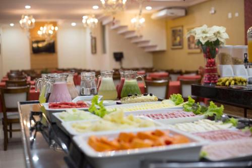 a buffet line with many different types of food at Lotus Hotel - à 6 km do Santuário de Aparecida-SP in Guaratinguetá