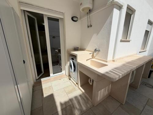 a bathroom with a sink and a washing machine at Casa Ca 'Luci in Marina San Gregorio