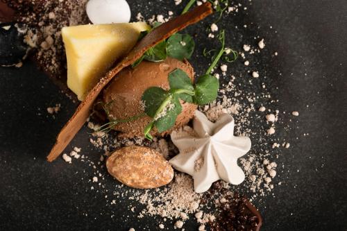 a plate of food with cheese and plants on it at Sandford Springs Hotel and Golf Club in Kingsclere