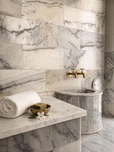 a bathroom with a sink and a marble wall at L'ADRESSE Boutique Hôtel & SPA Tanger in Tangier