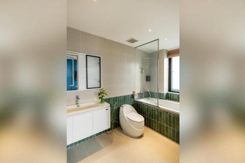 a bathroom with a toilet and a sink and a tub at Well-being Home - Self-Service in Hanoi