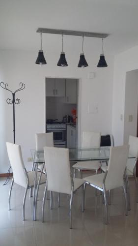 a dining room with a glass table and white chairs at Piso exclusivo en Rosario! "Altos de Rosario" in Rosario