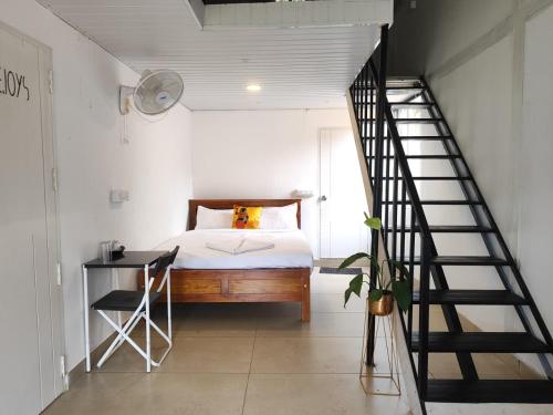 a bedroom with a bed and a staircase at Rays of Bliss in Mananthavady