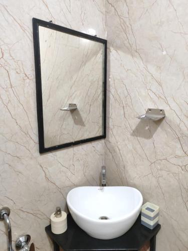 a bathroom with a white sink and a mirror at Rays of Bliss in Mananthavady