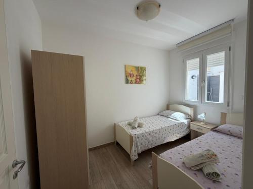 a small bedroom with two beds and a window at Casa Ca 'Luci in Marina San Gregorio