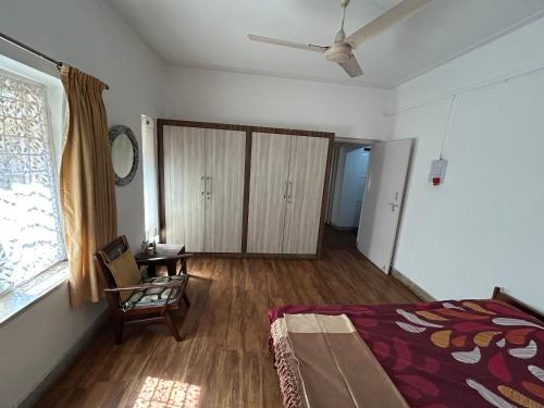 a bedroom with a bed and a chair and a window at Leos Inn in Pune