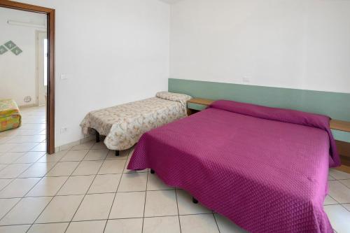 a bedroom with a purple bed and a mirror at Residenza Stella X in Bibione
