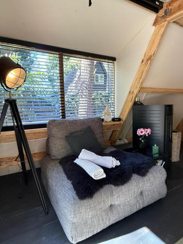 a living room with a couch and a window at Het Dubbele Punthuisje in Lanaken
