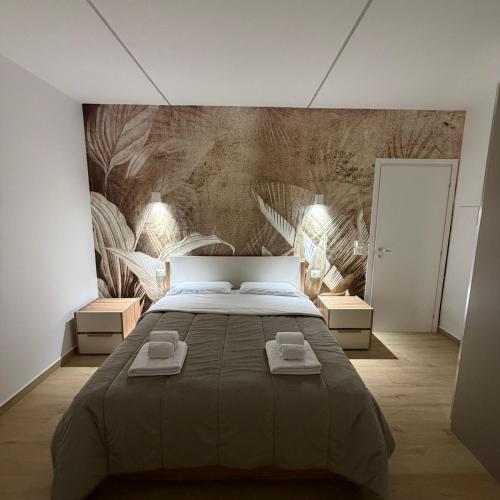 a bedroom with a large bed with two towels on it at Elled-home in Misterbianco