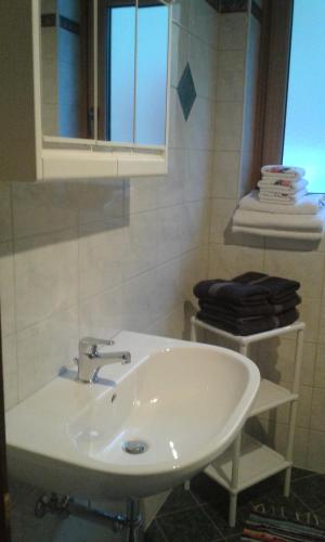 - białą umywalkę w łazience z oknem w obiekcie Ferienwohnung Kramserhof w mieście Heiligenblut