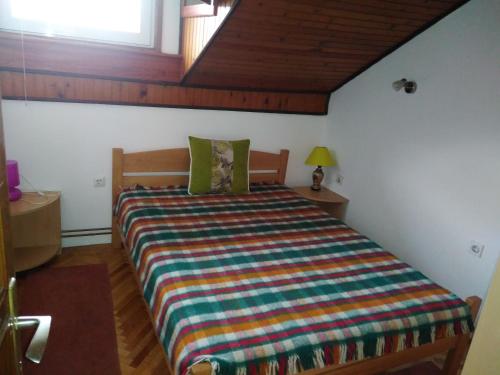 a bedroom with a bed with a colorful striped comforter at Apartmani Lucky in Vrnjačka Banja