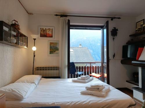 a bedroom with a large bed with towels on it at Mountain Haven Free parking in Temù